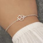 ezüst színű macskás karkötő kézen, macska medállal