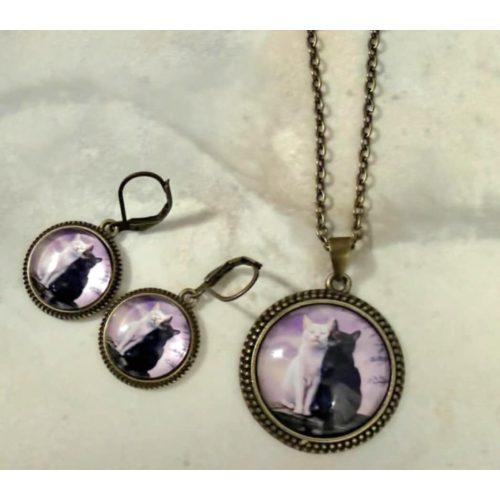 lila macskás ékszerszett medállal és fülbevalóval közelről