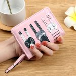 Rózsaszín női pénztárca három cicával, kézben tartva