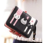 Cicás mintás női pénztárca fekete-rózsaszín színben, kézben tartva