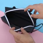 Fekete cicás tolltartó használat közben, nyitott cipzárral – Doromboló Webshop